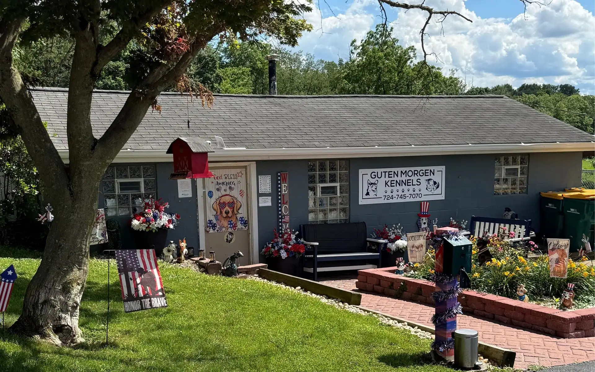 The front of Guten Morgen Kennels with flower beds and the kennel sign